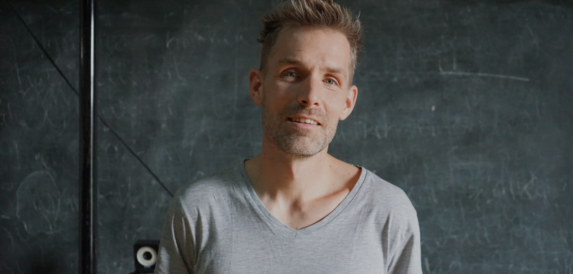 A man standing in front of a blackboard